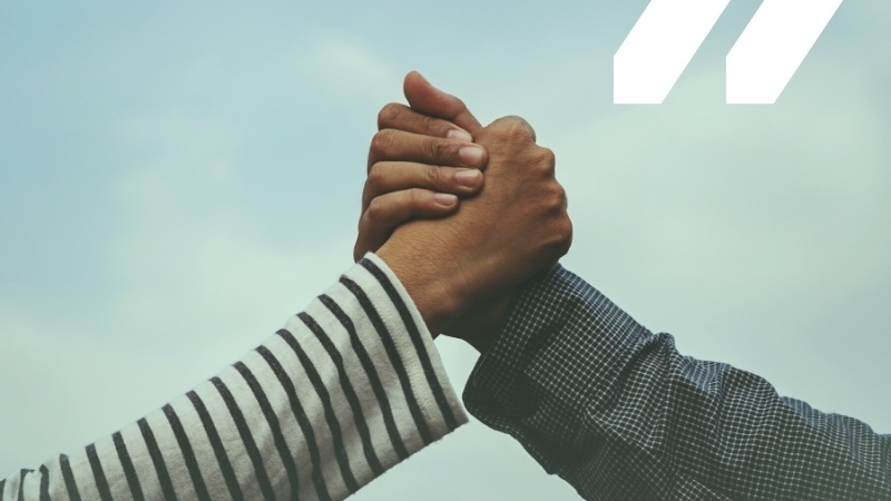 Image of two hands clasped together in a handshake.