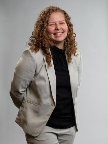 Trish Caldwell wearing a black shirt and light gray suit